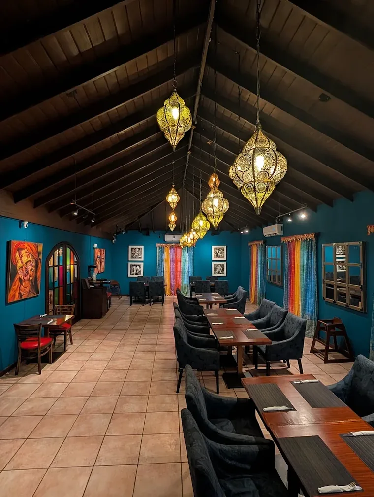 Indian Summer blue dining room with hanging lamps and set tables