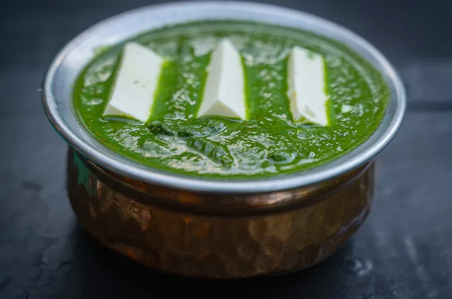 Saag paneer served in a copper bowl